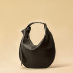 The Saddle Bag IVY by LABEL17 is crafted from supple, vegetable-tanned nappa leather and defined by its distinctive hand-stitched side seams. Its softly curved saddle silhouette rests comfortably against the body. The bag features a zip closure, a leather-lined interior, and a secure inner pocket. The adjustable strap allows it to be worn over the shoulder or crossbody – a versatile piece for everyday use. Handmade in Morocco.