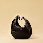 The Saddle Bag IVY by LABEL17 is crafted from supple, vegetable-tanned nappa leather and defined by its distinctive hand-stitched side seams. Its softly curved saddle silhouette rests comfortably against the body. The bag features a zip closure, a leather-lined interior, and a secure inner pocket. The adjustable strap allows it to be worn over the shoulder or crossbody – a versatile piece for everyday use. Handmade in Morocco.