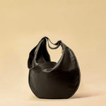 The Saddle Bag IVY by LABEL17 is crafted from supple, vegetable-tanned nappa leather and defined by its distinctive hand-stitched side seams. Its softly curved saddle silhouette rests comfortably against the body. The bag features a zip closure, a leather-lined interior, and a secure inner pocket. The adjustable strap allows it to be worn over the shoulder or crossbody – a versatile piece for everyday use. Handmade in Morocco.