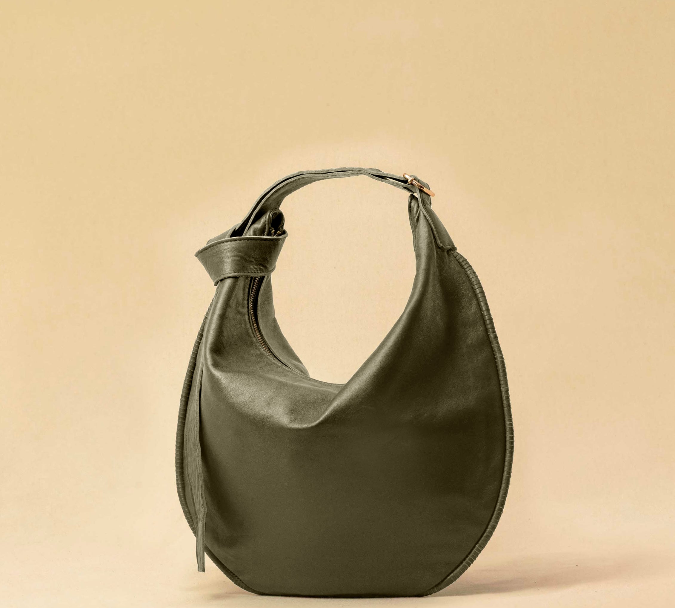 The Saddle Bag IVY by LABEL17 is crafted from supple, vegetable-tanned nappa leather and defined by its distinctive hand-stitched side seams. Its softly curved saddle silhouette rests comfortably against the body. The bag features a zip closure, a leather-lined interior, and a secure inner pocket. The adjustable strap allows it to be worn over the shoulder or crossbody – a versatile piece for everyday use. Handmade in Morocco.