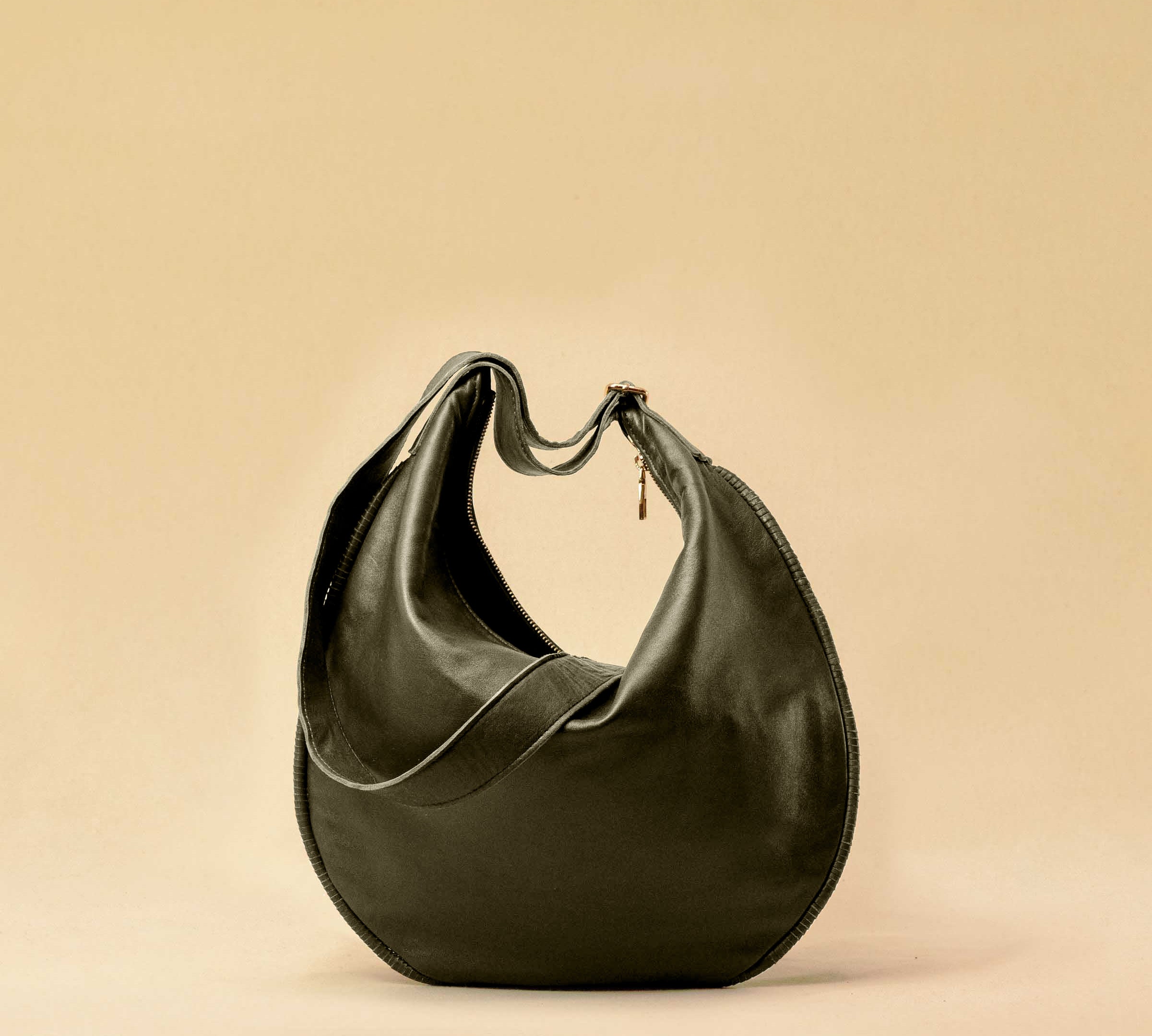 The Saddle Bag IVY by LABEL17 is crafted from supple, vegetable-tanned nappa leather and defined by its distinctive hand-stitched side seams. Its softly curved saddle silhouette rests comfortably against the body. The bag features a zip closure, a leather-lined interior, and a secure inner pocket. The adjustable strap allows it to be worn over the shoulder or crossbody – a versatile piece for everyday use. Handmade in Morocco.