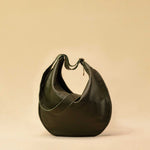 The Saddle Bag IVY by LABEL17 is crafted from supple, vegetable-tanned nappa leather and defined by its distinctive hand-stitched side seams. Its softly curved saddle silhouette rests comfortably against the body. The bag features a zip closure, a leather-lined interior, and a secure inner pocket. The adjustable strap allows it to be worn over the shoulder or crossbody – a versatile piece for everyday use. Handmade in Morocco.