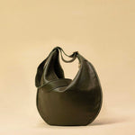 The Saddle Bag IVY by LABEL17 is crafted from supple, vegetable-tanned nappa leather and defined by its distinctive hand-stitched side seams. Its softly curved saddle silhouette rests comfortably against the body. The bag features a zip closure, a leather-lined interior, and a secure inner pocket. The adjustable strap allows it to be worn over the shoulder or crossbody – a versatile piece for everyday use. Handmade in Morocco.