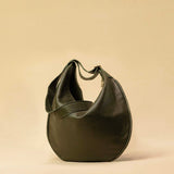 The Saddle Bag IVY by LABEL17 is crafted from supple, vegetable-tanned nappa leather and defined by its distinctive hand-stitched side seams. Its softly curved saddle silhouette rests comfortably against the body. The bag features a zip closure, a leather-lined interior, and a secure inner pocket. The adjustable strap allows it to be worn over the shoulder or crossbody – a versatile piece for everyday use. Handmade in Morocco.