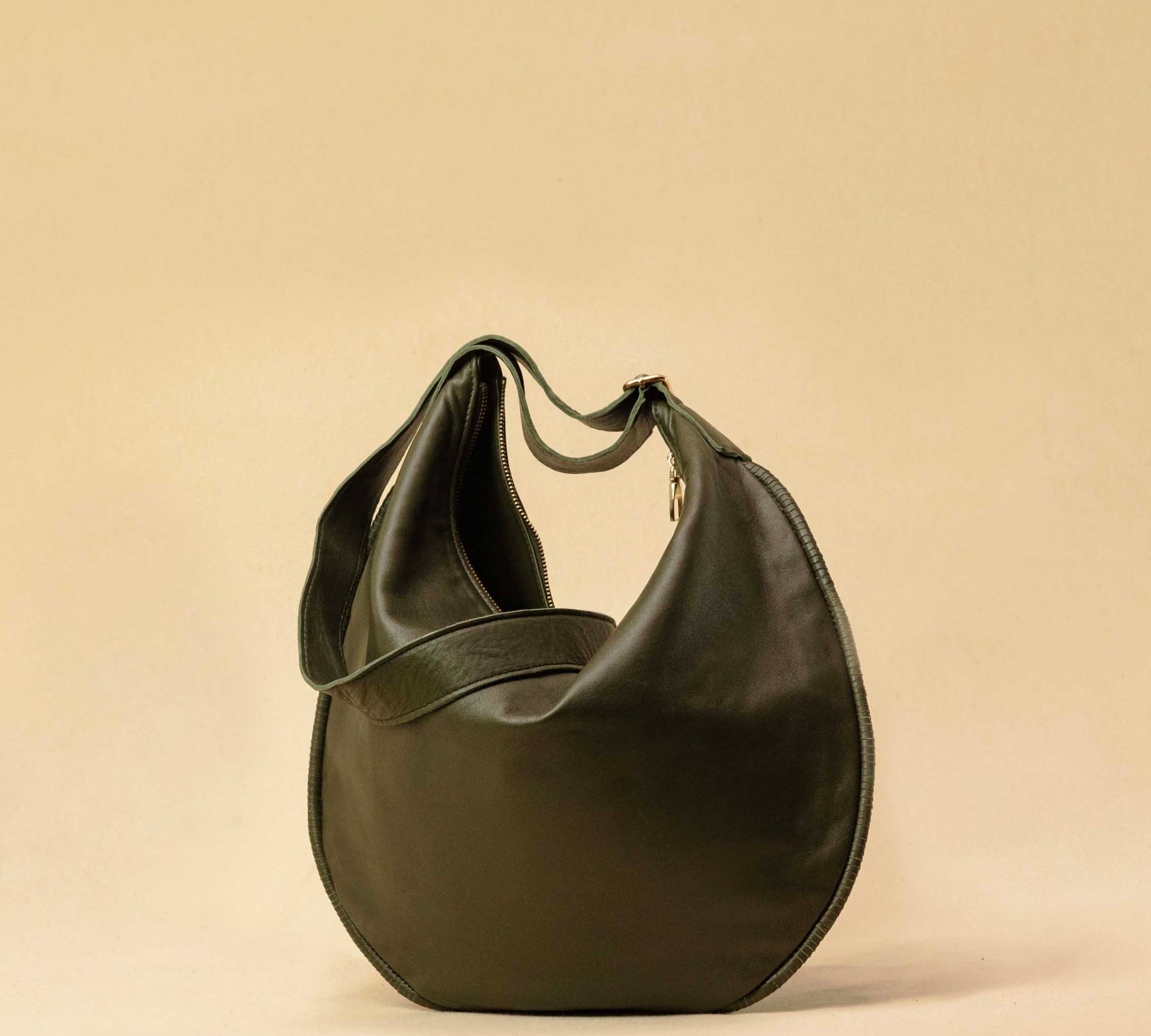 The Saddle Bag IVY by LABEL17 is crafted from supple, vegetable-tanned nappa leather and defined by its distinctive hand-stitched side seams. Its softly curved saddle silhouette rests comfortably against the body. The bag features a zip closure, a leather-lined interior, and a secure inner pocket. The adjustable strap allows it to be worn over the shoulder or crossbody – a versatile piece for everyday use. Handmade in Morocco.