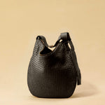 The Saddle Bag LUNA by LABEL17 is hand-braided from the finest vegetable-tanned nappa leather. Its softly curved saddle shape is elegantly defined by a delicate piped seam, allowing it to rest comfortably against the body. It features a zip closure, a leather-lined interior, and a secure inner pocket. The adjustable strap allows for shoulder or crossbody wear – a versatile companion for every day. Handmade in Morocco.