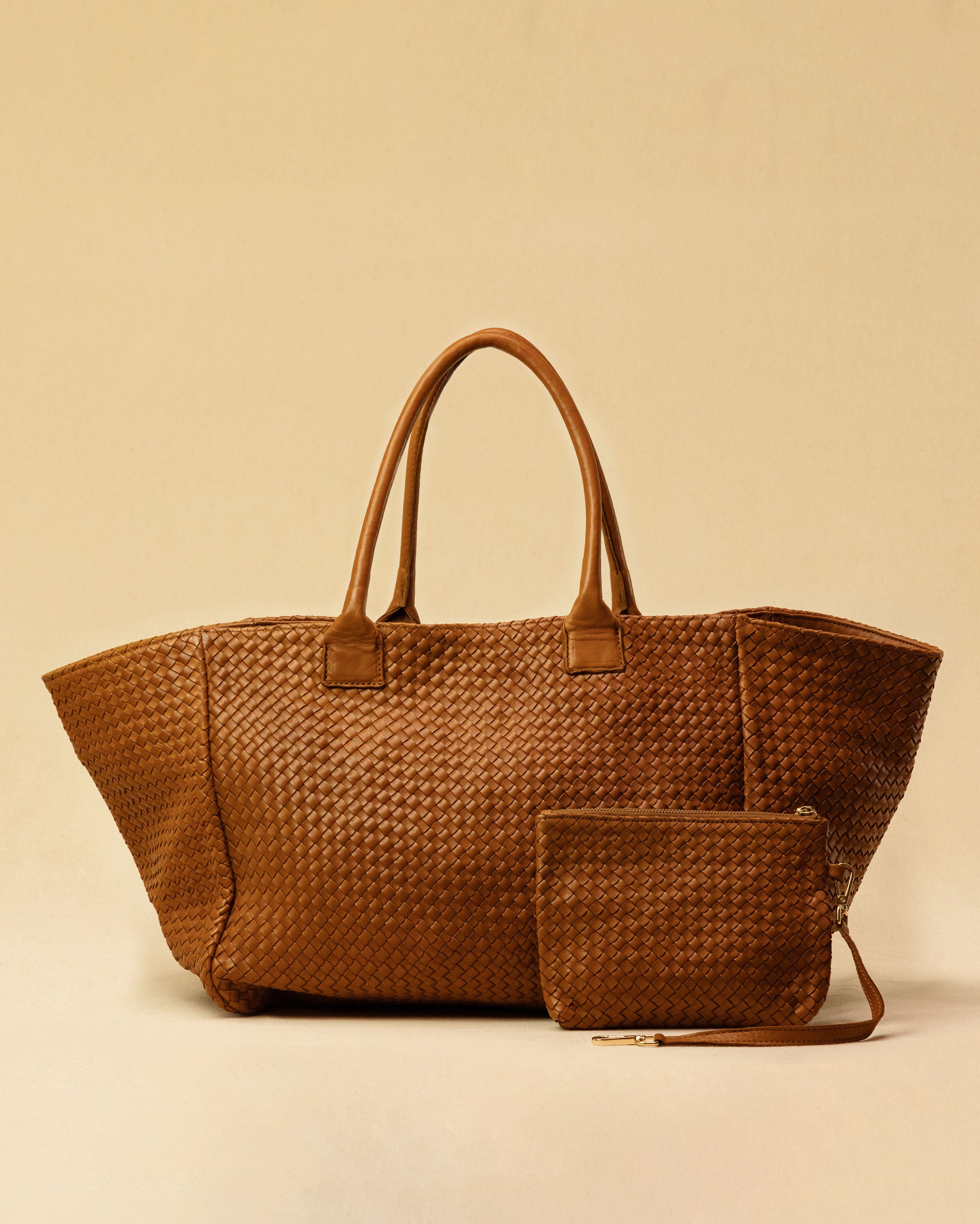 The Shoulder Bag ORIGINAL XL (Weekender) by LABEL17 is made from supple, vegetable-tanned nappa leather. The hand-braided leather bag can be made smaller on both sides from the inside with press studs and also includes a detachable, hand-braided pouch for organization inside the bag.