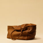 The Shoulder Bag ORIGINAL XL (Weekender) by LABEL17 is made from supple, vegetable-tanned nappa leather. The hand-braided leather bag can be made smaller on both sides from the inside with press studs and also includes a detachable, hand-braided pouch for organization inside the bag.