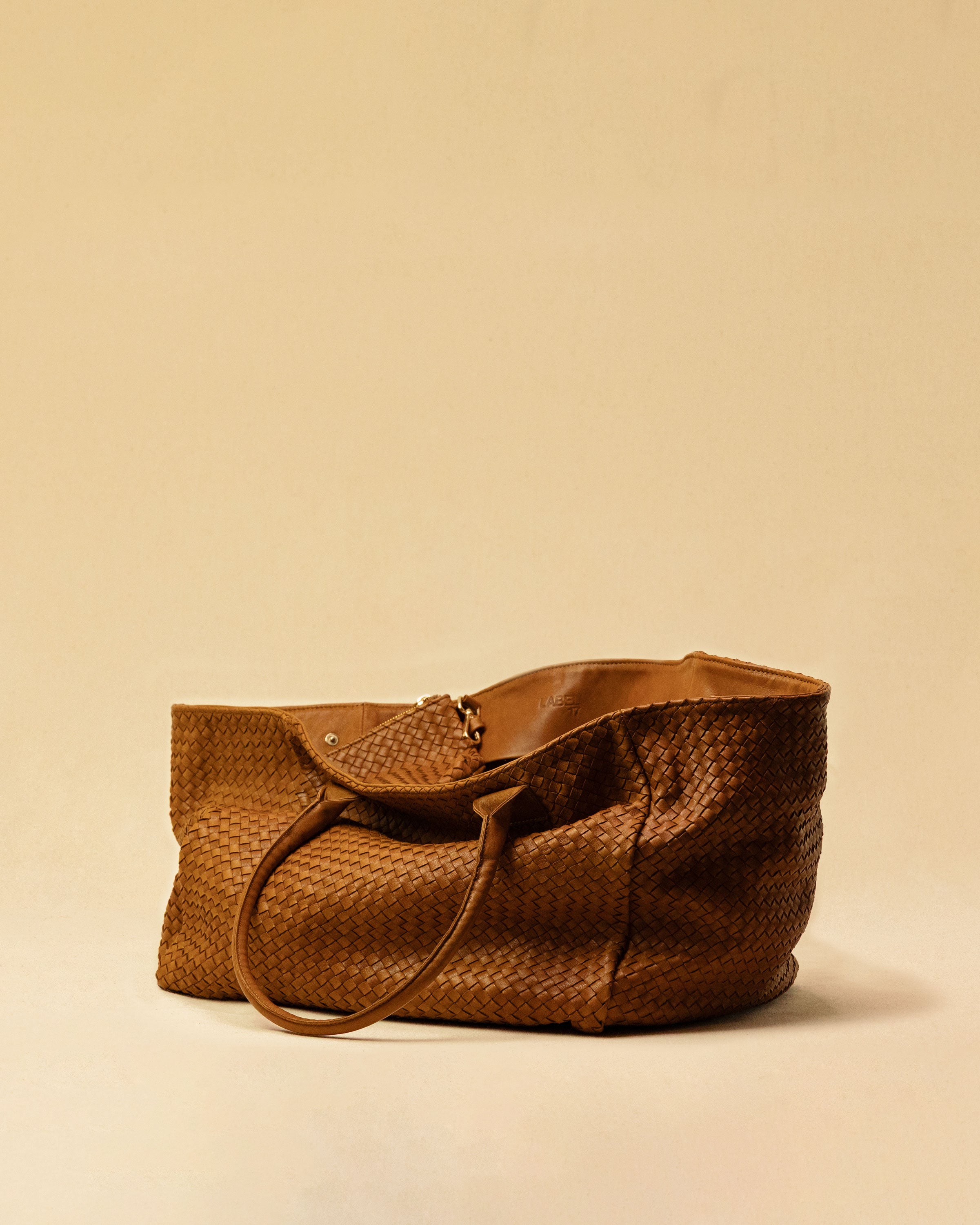 The Shoulder Bag ORIGINAL XL (Weekender) by LABEL17 is made from supple, vegetable-tanned nappa leather. The hand-braided leather bag can be made smaller on both sides from the inside with press studs and also includes a detachable, hand-braided pouch for organization inside the bag.