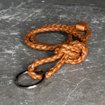 The LABEL17 Braided Keyring Necklace, is made of supple lamb nappa and is braided by hand, color cognac. The Keyring can be worn around the neck or attached to your handbag