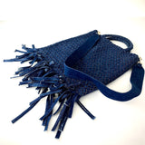 Die Crossbody Bag Tresse Fringes Denim von LABEL17 mit geflochtenen Henkeln und langem abnehmbarem Schulterriemen, ist aus gewaschenem Denim gefertigt und von Hand geflochten.
