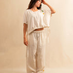 Die Drawstring Blouse LINA von LABEL17 hat einen runden Halsausschnitt und einen verstellbaren Tunnelzug am Saum. Aus einem leichten Leinen-Baumwoll-Mischgewebe ist dieses Top angenehm auf der Haut und ideal für warme Tage. Veredelt mit drei handgehäkelten Blumen in verschiedenen Grössen und Farben.