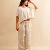 Die Drawstring Blouse LINA von LABEL17 hat einen runden Halsausschnitt und einen verstellbaren Tunnelzug am Saum. Aus einem leichten Leinen-Baumwoll-Mischgewebe ist dieses Top angenehm auf der Haut und ideal für warme Tage. Veredelt mit drei handgehäkelten Blumen in verschiedenen Grössen und Farben.