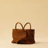 The Cabas Medium by LABEL17 is a lightweight handbag crafted from supple, vegetable-tanned nappa leather. Hand-braided and finished with a zip closure and detachable shoulder strap, it features a leather-lined interior with a secure inner pocket – combining refined design with everyday functionality. Handmade in Morocco.