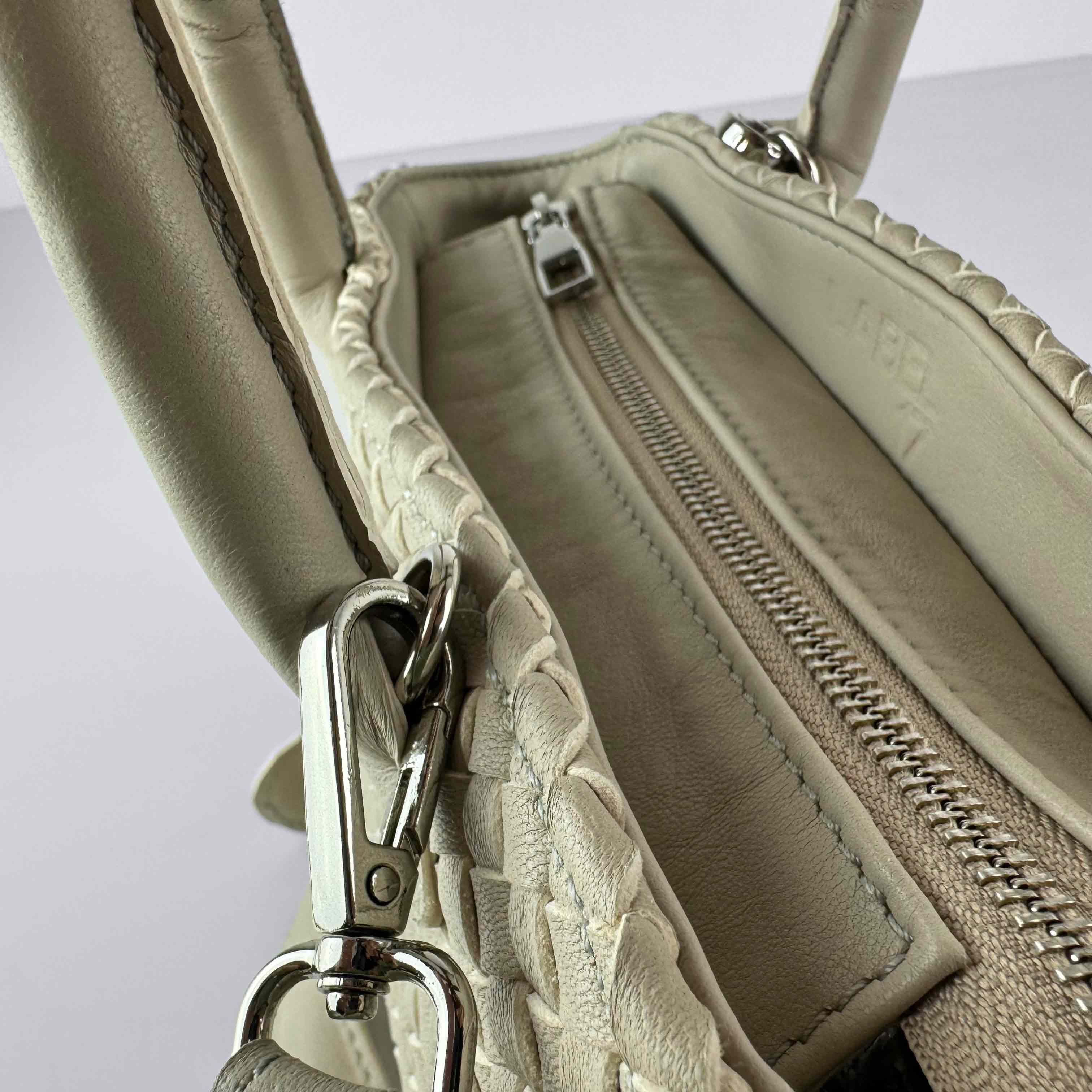 Die Handbag Cabas Tresse  Mini von LABEL17 ist eine kleine, leichte Handtasche aus geschmeidigem, pflanzlich gegerbtem Nappaleder. Die von Hand geflochtene Tasche hat einen Reissverschluss und abnehmbaren Schulterriemen und ist innen mit Leder und einer verschliessbaren Innentasche ausgestattet. Tragbar als Crossbody oder in der Hand.
