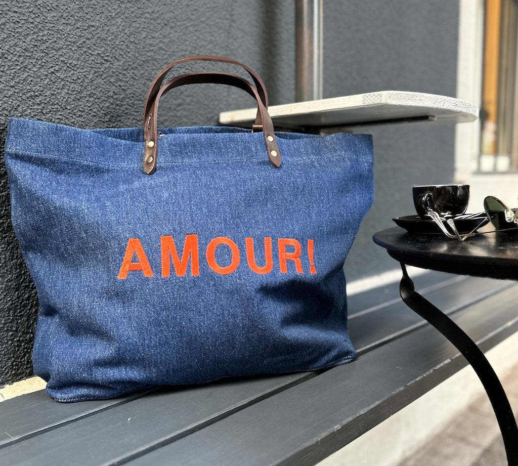 Bestickte Stofftasche von LABEL17 mit braunen Lederhenkeln und AMOUR Botschaft auf der Vorderseite.  Hergestellt in Marokko