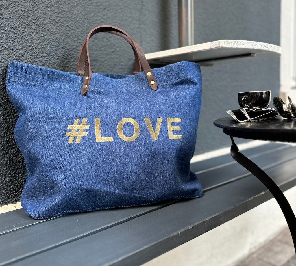 Bestickte Stofftasche von LABEL17 mit braunen Lederhenkeln und #LOVE Botschaft auf der Vorderseite.  Hergestellt in Marokko