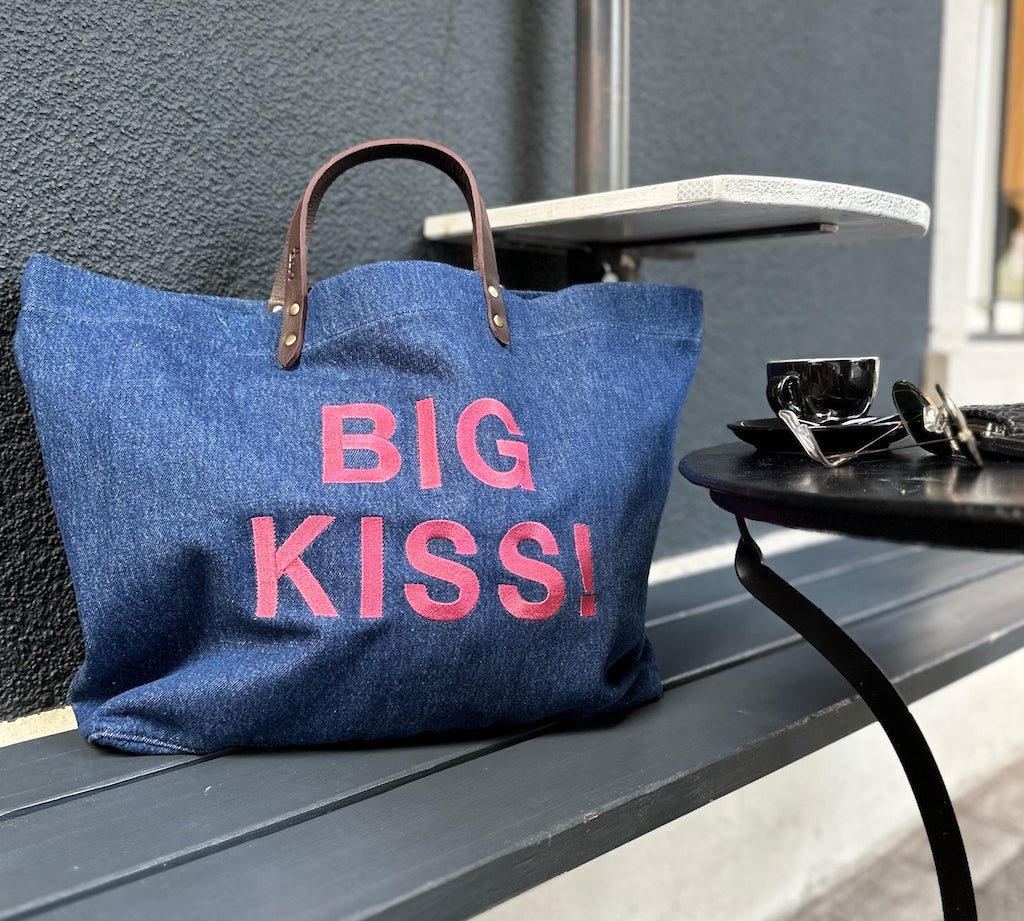 Bestickte Stofftasche von LABEL17 mit braunen Lederhenkeln und BIG KISS Botschaft auf der Vorderseite. Hergestellt in Marokko