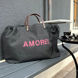 Bestickte Stofftasche von LABEL17 mit braunen Lederhenkeln und AMORE! Botschaft auf der Vorderseite. Hergestellt in Marokko