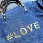 Bestickte Stofftasche von LABEL17 mit braunen Lederhenkeln und #LOVE Botschaft auf der Vorderseite. Hergestellt in Marokko