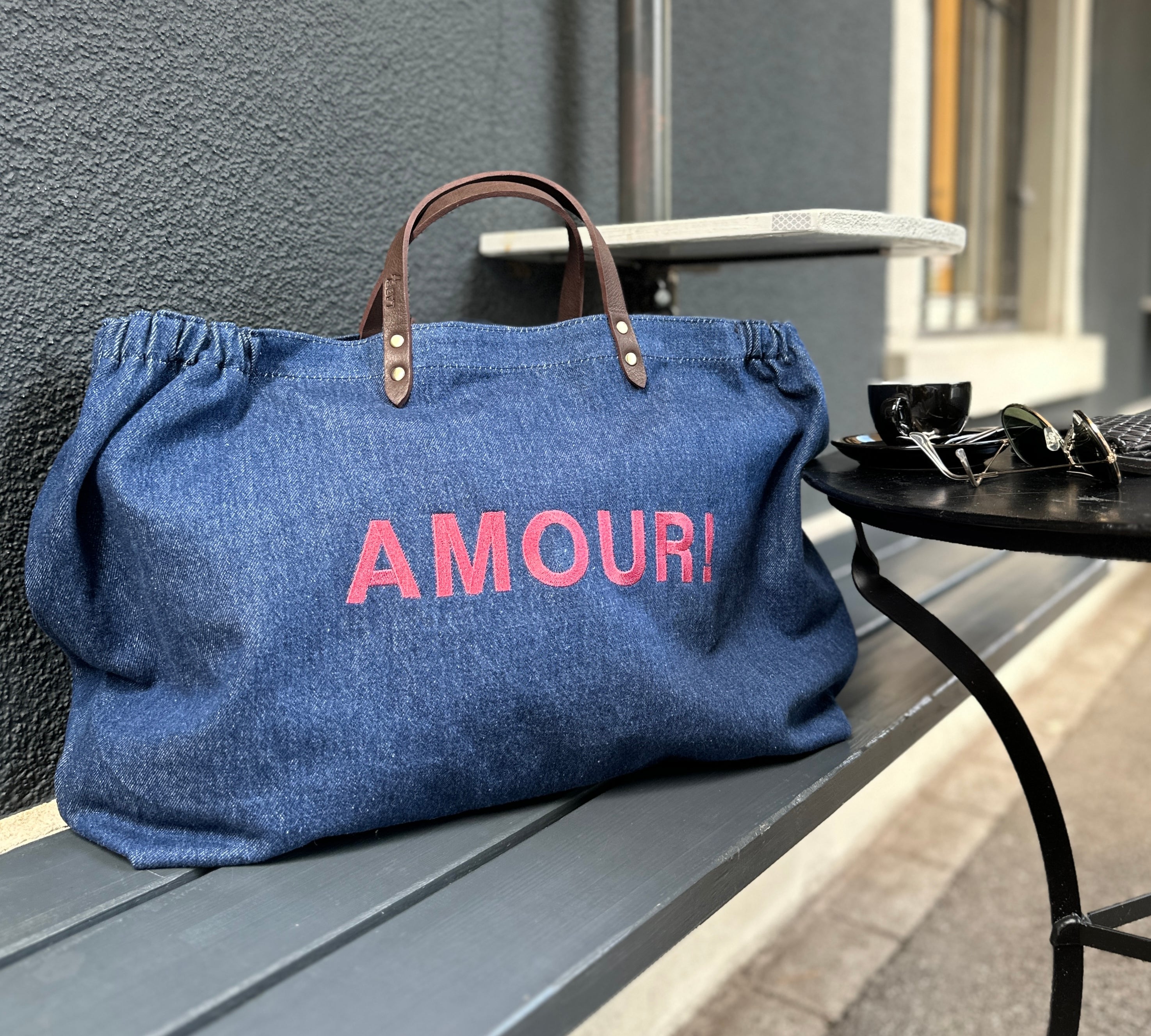 Bestickte Stofftasche von LABEL17 mit braunen Lederhenkeln und AMOUR Botschaft auf der Vorderseite. Hergestellt in Marokko