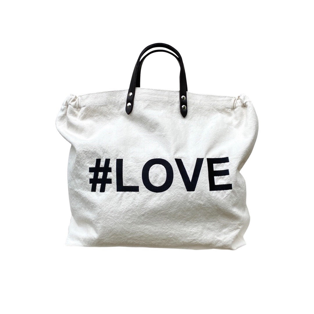 Bestickte Stofftasche von LABEL17 mit braunen Lederhenkeln und #LOVE Botschaft auf der Vorderseite.  Hergestellt in Marokko