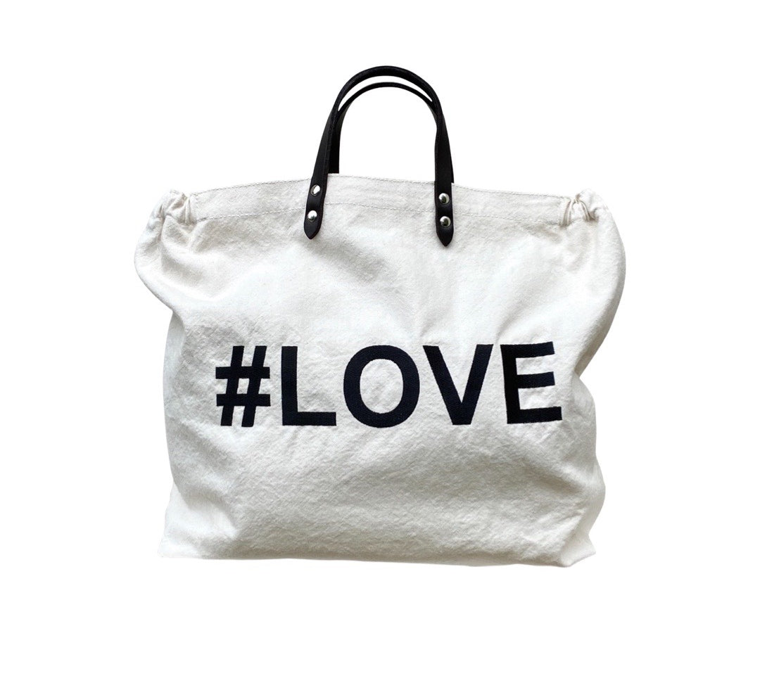 Bestickte Stofftasche von LABEL17 mit braunen Lederhenkeln und #LOVE Botschaft auf der Vorderseite.  Hergestellt in Marokko