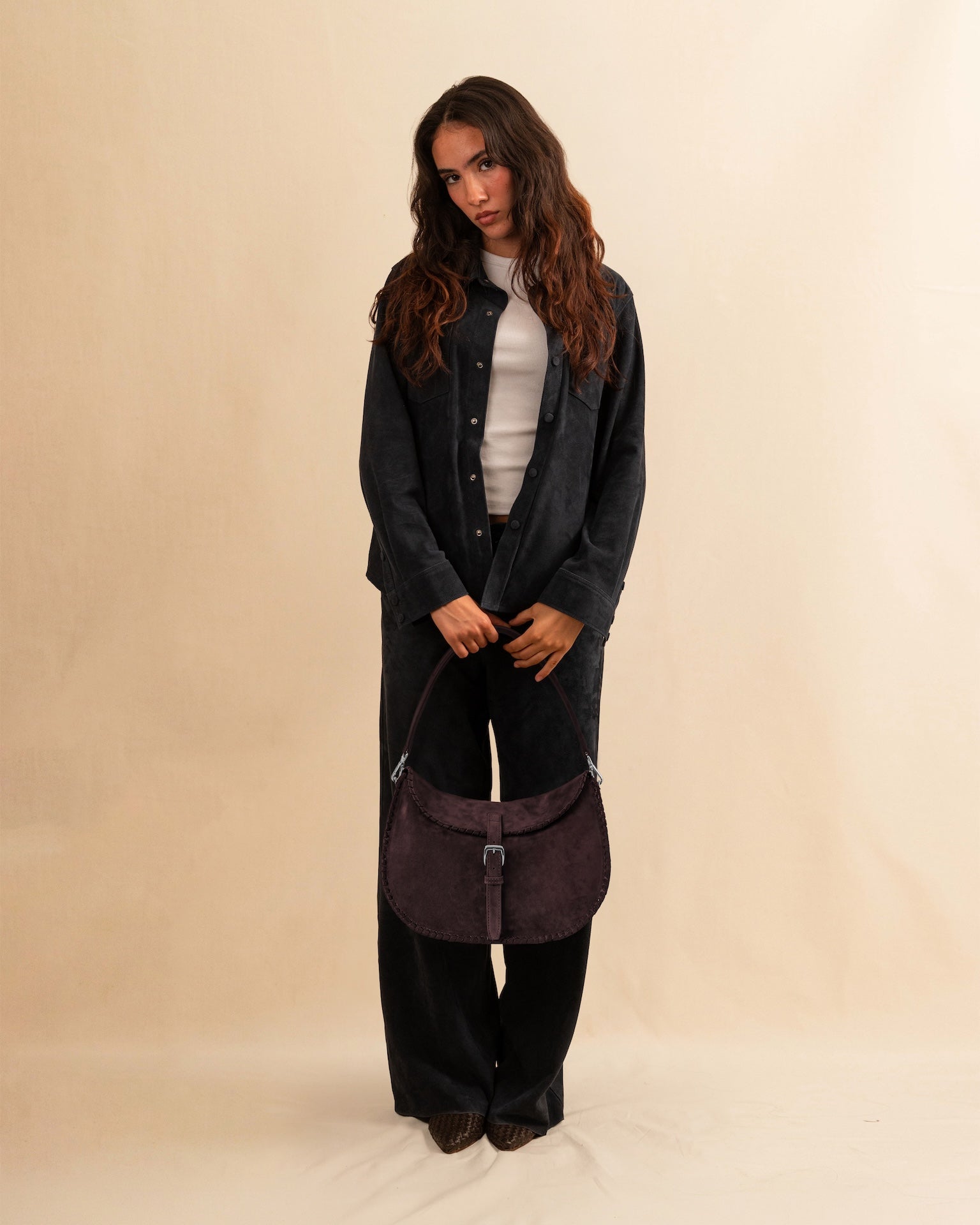 Die Horse Bag FRANCA von LABEL17 ist aus geschmeidigem Velours-Leder gefertigt und zeichnet sich durch seine stilvolle Form aus. Der Schulterriemen ermöglicht das Tragen über der Schulter oder als Handtasche. Ein vielseitiges Accessoire mit schlichter, moderner Eleganz.