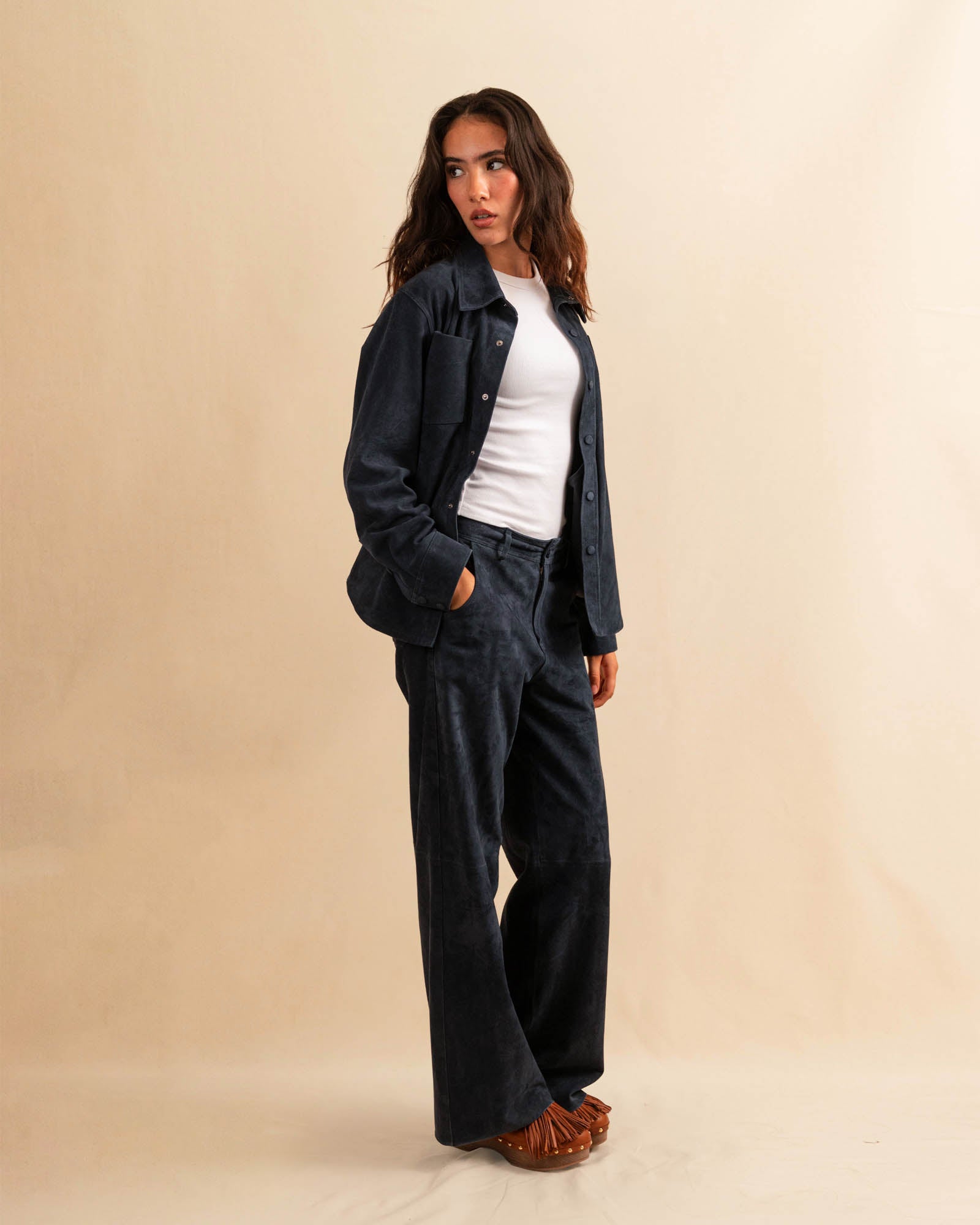 Unsere Wide Leg Leather Pants CLEO ist aus feinstem Veloursleder gefertigt und besticht durch seine sanft ausgestellte A-Linienform. Die weich fliessende Silhouette schmeichelt der Figur und verleiht dem Look eine besondere Note – lässig und stilvoll zugleich.