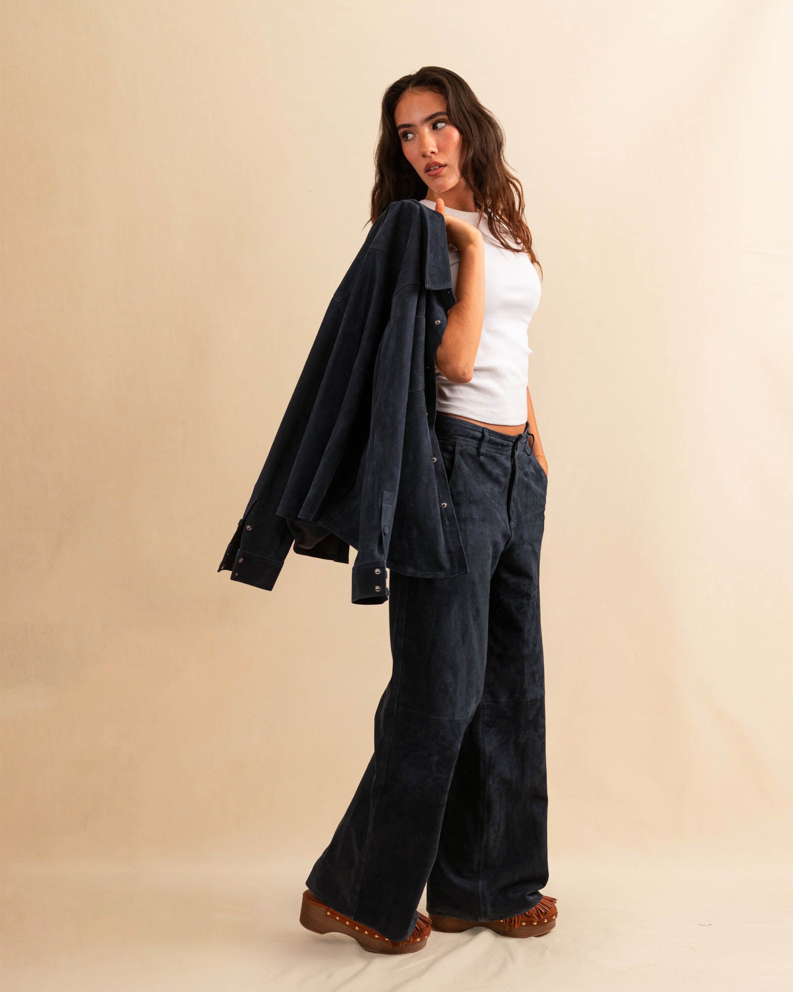 Unsere Wide Leg Leather Pants CLEO ist aus feinstem Veloursleder gefertigt und besticht durch seine sanft ausgestellte A-Linienform. Die weich fliessende Silhouette schmeichelt der Figur und verleiht dem Look eine besondere Note – lässig und stilvoll zugleich.
