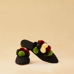 Leicht und verspielt bestechen die schwarzen Raffia Mules GELATO von LABEL17 durch die reduzierte Form und die farbigen Pompoms als Highlight. Von Hand geflochten, ein raffiniertes Essential für den Sommer.