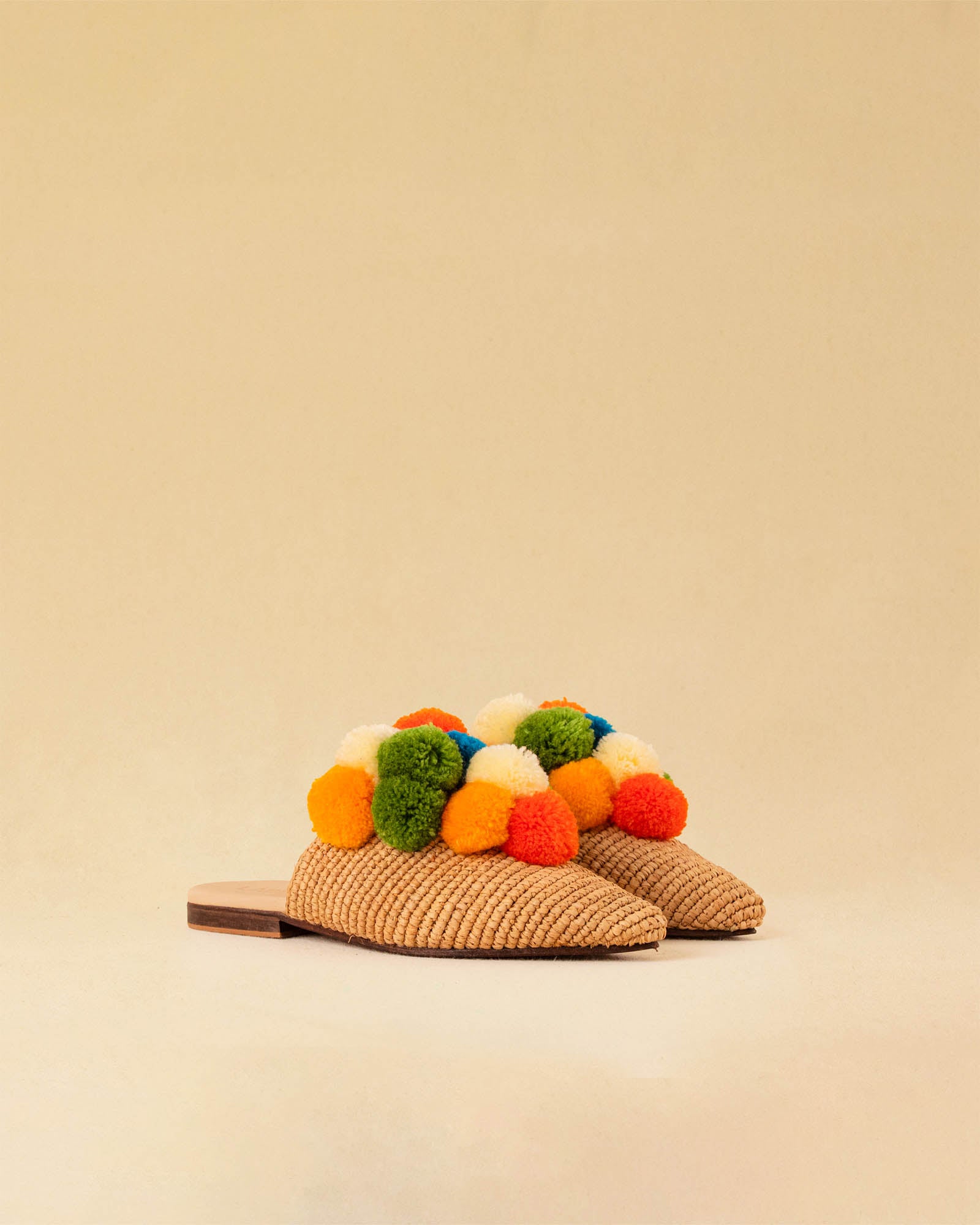 Leicht und verspielt bestechen die nuturfarbene Raffia Mules GELATO von LABEL17 durch die reduzierte Form und die farbigen Pompoms als Highlight. Von Hand geflochten, ein raffiniertes Essential für den Sommer.