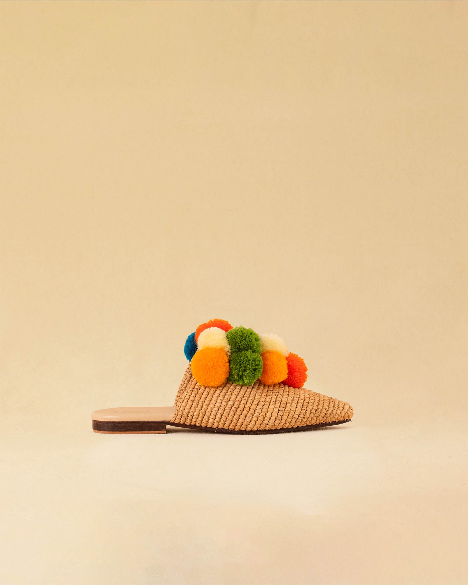 Leicht und verspielt bestechen die nuturfarbene Raffia Mules GELATO von LABEL17 durch die reduzierte Form und die farbigen Pompoms als Highlight. Von Hand geflochten, ein raffiniertes Essential für den Sommer.