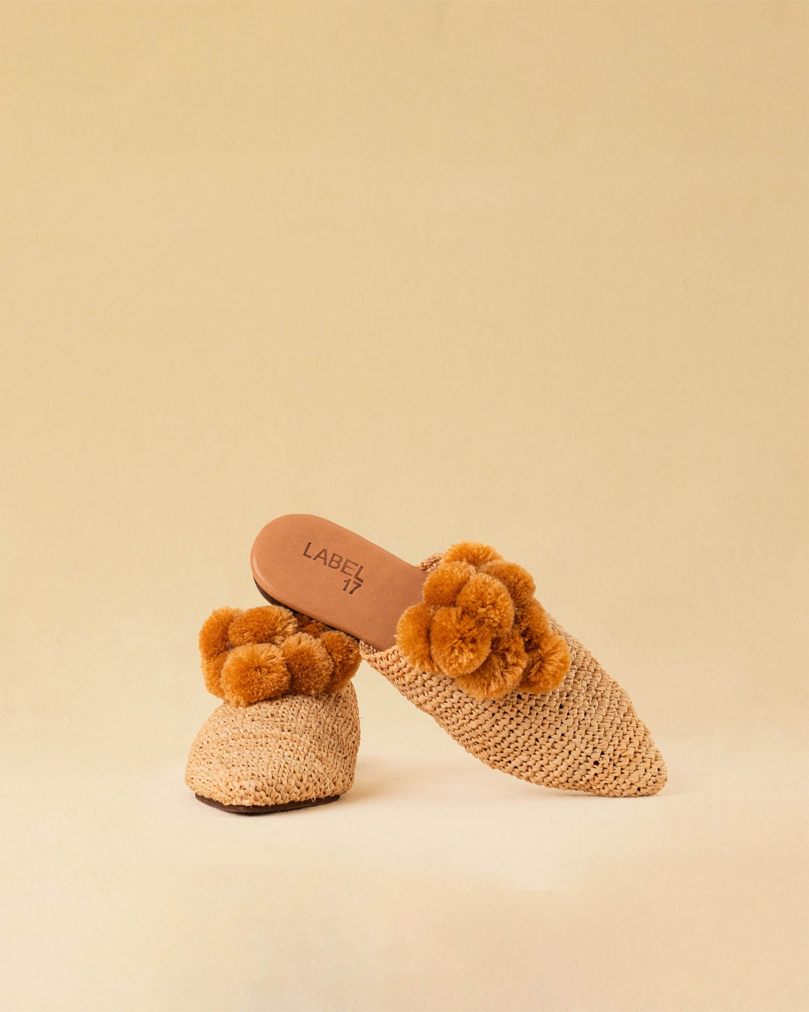Leicht und verspielt bestechen die nuturfarbene Raffia Mules GELATO von LABEL17 durch die reduzierte Form und die naturfarbenen Pompoms als Highlight. Von Hand geflochten, ein raffiniertes Essential für den Sommer.