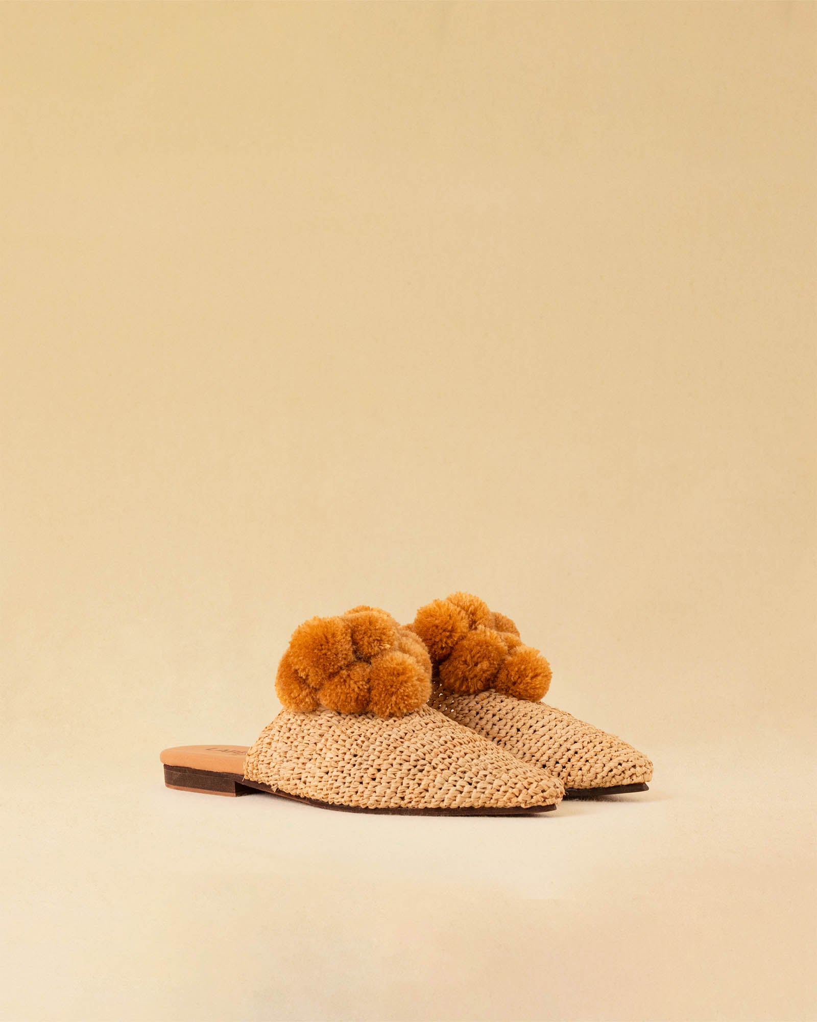 Leicht und verspielt bestechen die nuturfarbene Raffia Mules GELATO von LABEL17 durch die reduzierte Form und die naturfarbenen Pompoms als Highlight. Von Hand geflochten, ein raffiniertes Essential für den Sommer.
