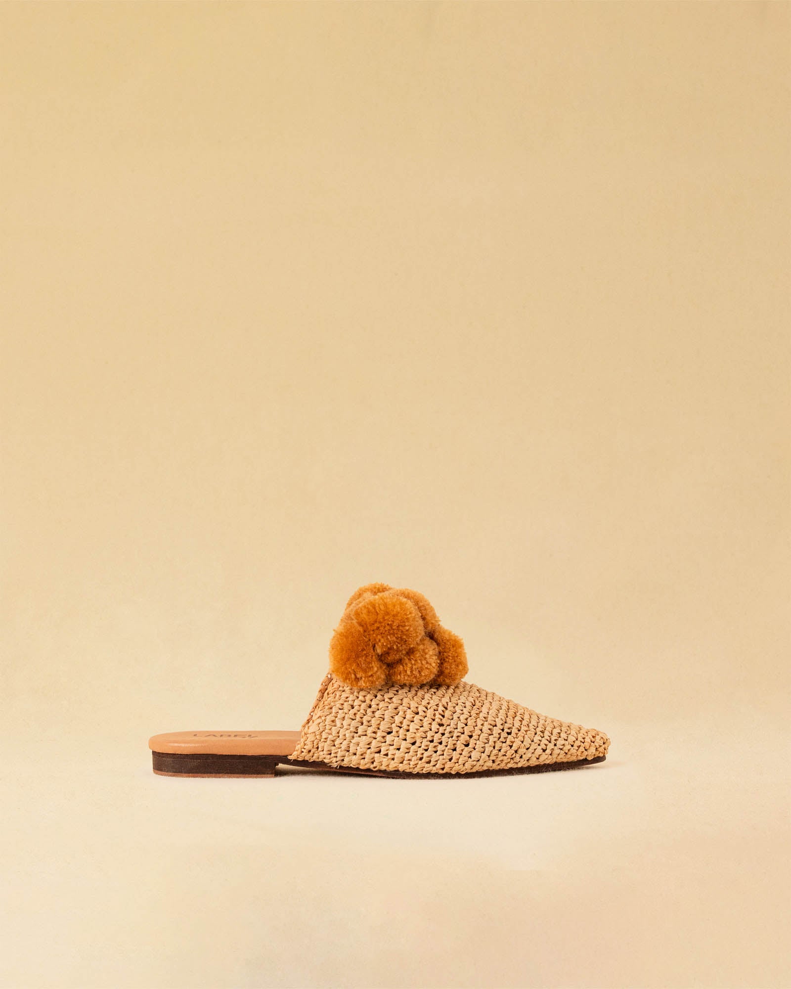Leicht und verspielt bestechen die nuturfarbene Raffia Mules GELATO von LABEL17 durch die reduzierte Form und die naturfarbenen Pompoms als Highlight. Von Hand geflochten, ein raffiniertes Essential für den Sommer.