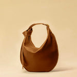 The Saddle Bag IVY by LABEL17 is crafted from supple, vegetable-tanned nappa leather and defined by its distinctive hand-stitched side seams. Its softly curved saddle silhouette rests comfortably against the body. The bag features a zip closure, a leather-lined interior, and a secure inner pocket. The adjustable strap allows it to be worn over the shoulder or crossbody – a versatile piece for everyday use. Handmade in Morocco.