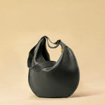 The Saddle Bag IVY by LABEL17 is crafted from supple, vegetable-tanned nappa leather and defined by its distinctive hand-stitched side seams. Its softly curved saddle silhouette rests comfortably against the body. The bag features a zip closure, a leather-lined interior, and a secure inner pocket. The adjustable strap allows it to be worn over the shoulder or crossbody – a versatile piece for everyday use. Handmade in Morocco.