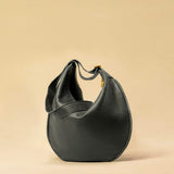 The Saddle Bag IVY by LABEL17 is crafted from supple, vegetable-tanned nappa leather and defined by its distinctive hand-stitched side seams. Its softly curved saddle silhouette rests comfortably against the body. The bag features a zip closure, a leather-lined interior, and a secure inner pocket. The adjustable strap allows it to be worn over the shoulder or crossbody – a versatile piece for everyday use. Handmade in Morocco.