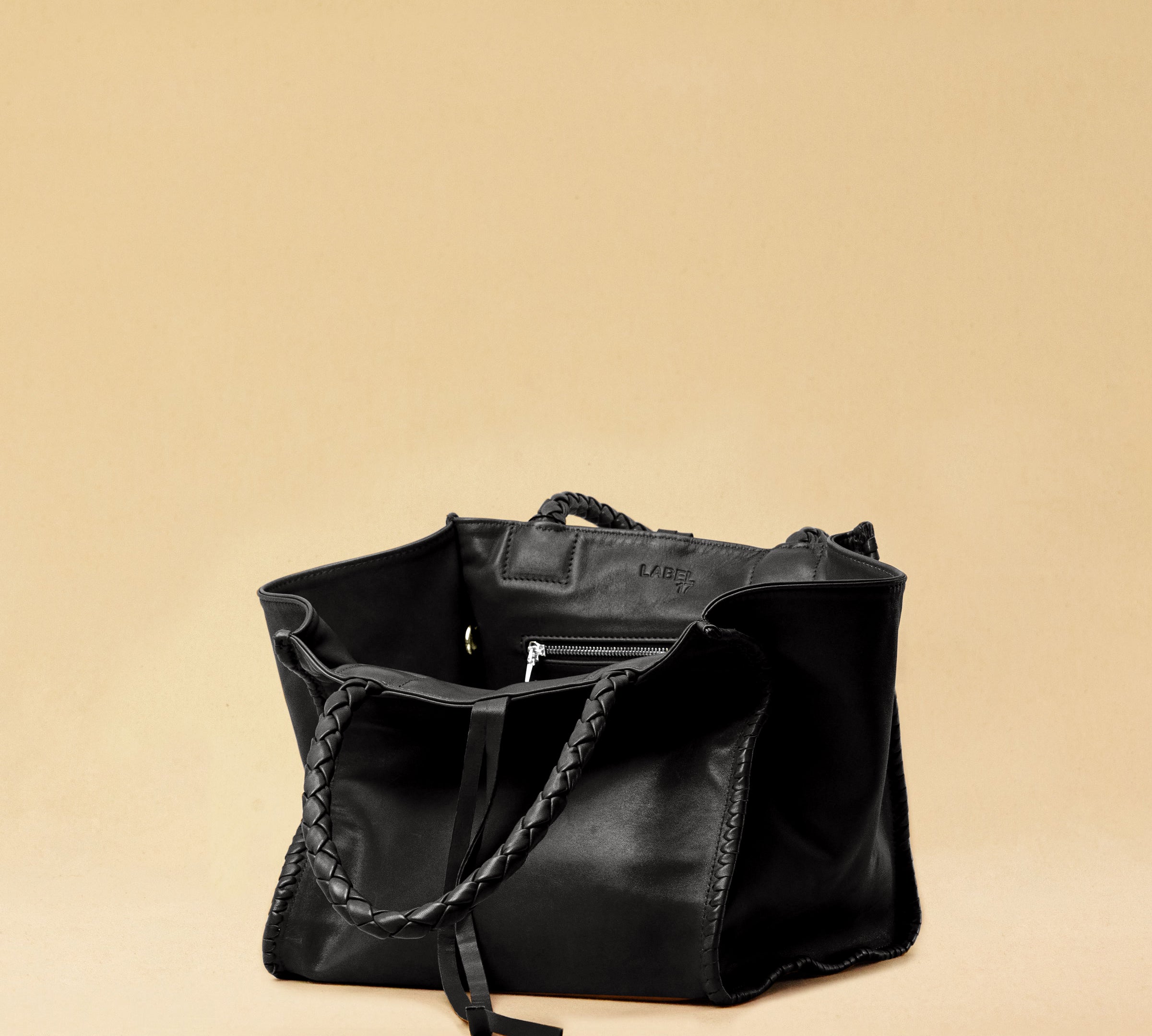 The Shoulder Bag IVY, crafted from supple, vegetable-tanned nappa leather, stands out for its artisanal detailing, distinctive side seams, and long braided handles. The interior lining and zippered side pocket are also made of fine nappa leather.