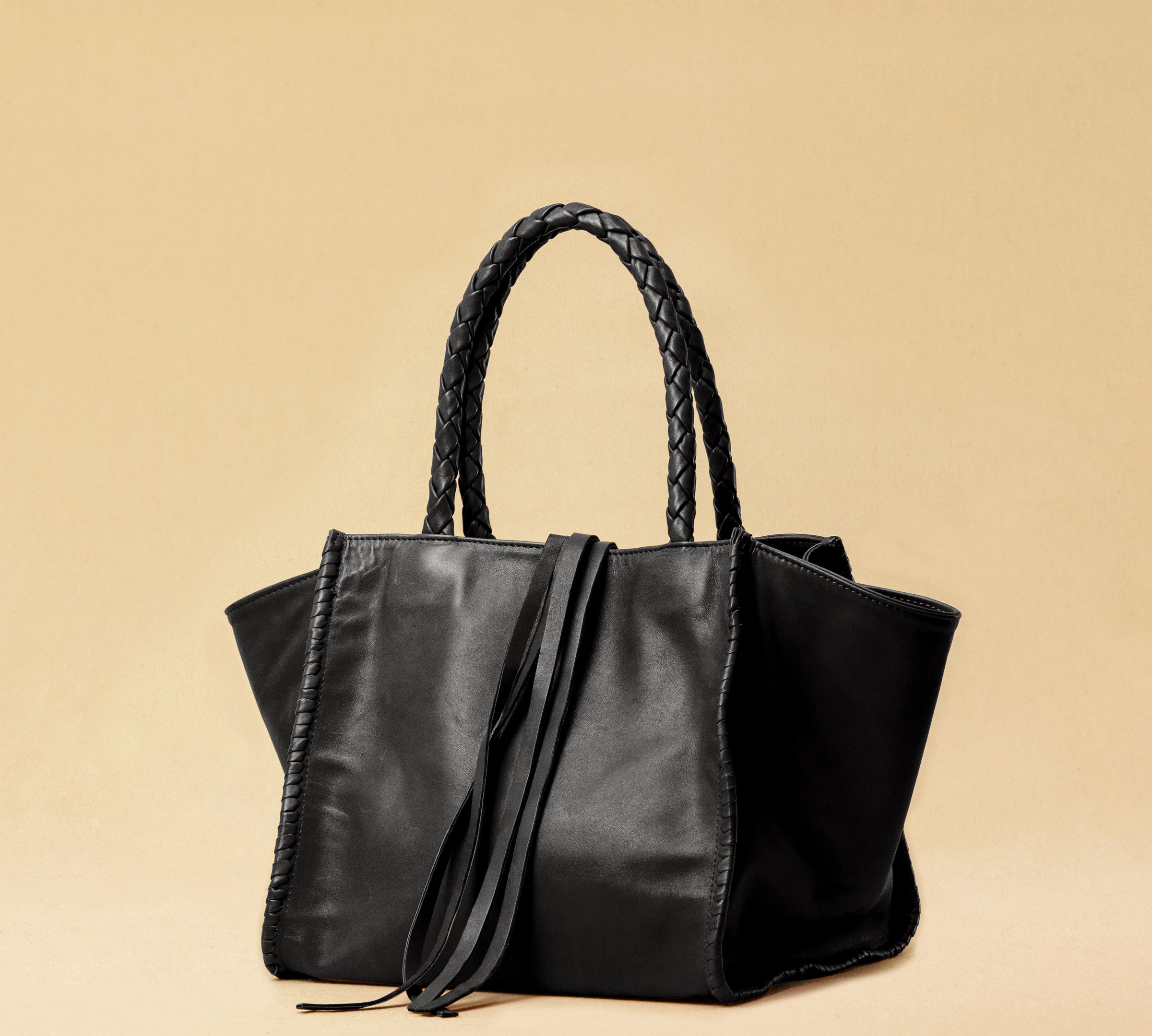 The Shoulder Bag IVY, crafted from supple, vegetable-tanned nappa leather, stands out for its artisanal detailing, distinctive side seams, and long braided handles. The interior lining and zippered side pocket are also made of fine nappa leather.