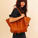 Die Shoulder Bag IVY von LABEL17 ist aus geschmeidigem Nappaleder gefertigt und zeichnet sich durch handwerkliche Details wie markante Seitennähte und lange, geflochtene Henkel aus. Mit den Lederbändern lässt sich die Tasche elegant zuschnüren – eine gelungene Verbindung von Funktion und Raffinesse.