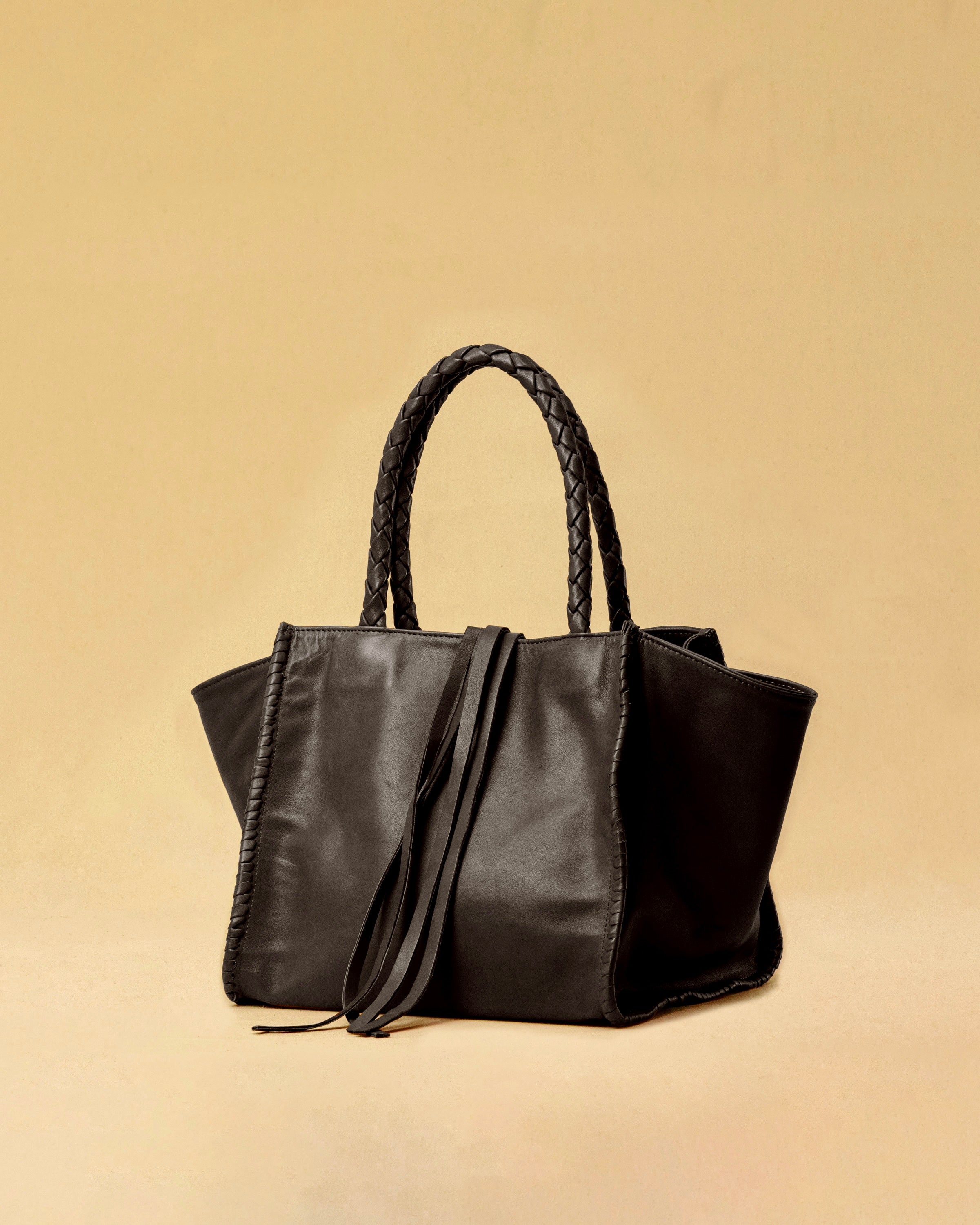 Die Shoulder Bag IVY ist aus geschmeidigem Nappaleder gefertigt und zeichnet sich durch handwerkliche Details wie markante Seitennähte und lange, geflochtene Henkel aus. Mit den Lederbändern lässt sich die Tasche elegant zuschnüren – eine gelungene Verbindung von Funktion und Raffinesse.&nbsp;