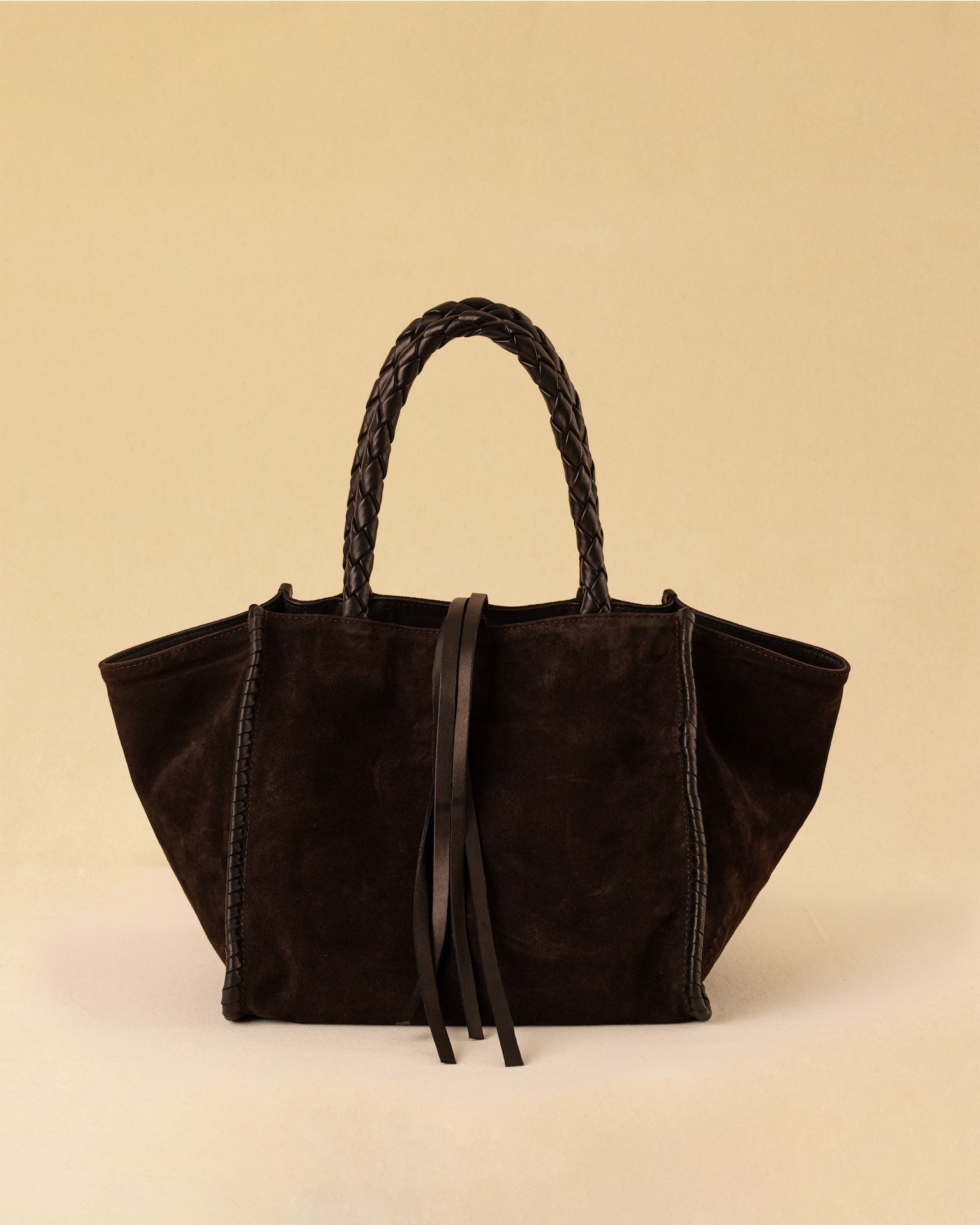 Die Shoulder Bag IVY von LABEL17 ist aus geschmeidigem Velours-Leder gefertigt und zeichnet sich durch handwerkliche Details wie markante Seitennähte und lange, geflochtene Henkel aus. Mit den Lederbändern lässt sich die Tasche elegant zuschnüren – eine gelungene Verbindung von Funktion und Raffinesse.