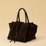 Die Shoulder Bag IVY von LABEL17 ist aus geschmeidigem Velours-Leder gefertigt und zeichnet sich durch handwerkliche Details wie markante Seitennähte und lange, geflochtene Henkel aus. Mit den Lederbändern lässt sich die Tasche elegant zuschnüren – eine gelungene Verbindung von Funktion und Raffinesse.