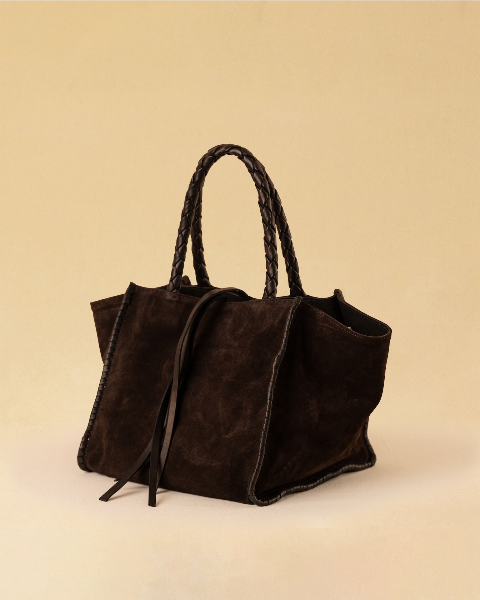 Die Shoulder Bag IVY von LABEL17 ist aus geschmeidigem Velours-Leder gefertigt und zeichnet sich durch handwerkliche Details wie markante Seitennähte und lange, geflochtene Henkel aus. Mit den Lederbändern lässt sich die Tasche elegant zuschnüren – eine gelungene Verbindung von Funktion und Raffinesse.