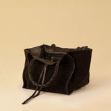 Die Shoulder Bag IVY von LABEL17 ist aus geschmeidigem Velours-Leder gefertigt und zeichnet sich durch handwerkliche Details wie markante Seitennähte und lange, geflochtene Henkel aus. Mit den Lederbändern lässt sich die Tasche elegant zuschnüren – eine gelungene Verbindung von Funktion und Raffinesse.
