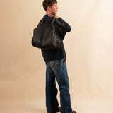 Die Shoulder Bag ORIGINAL XL von LABEL17, aus geschmeidigem Nappaleder von Hand geflochten, bietet grosszügigen Stauraum und eine variable Silhouette. Seitliche Druckknöpfe ermöglichen es, Form und Volumen der Tasche anzupassen. So wird aus dem geräumigen Weekender im Handumdrehen eine alltagstaugliche Begleiterin. Eine herausnehmbare, ebenfalls handgeflochtene Lederpouch sorgt für Ordnung im Inneren. Unisex.