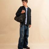 Die Shoulder Bag ORIGINAL XL von LABEL17, aus geschmeidigem Nappaleder von Hand geflochten, bietet grosszügigen Stauraum und eine variable Silhouette. Seitliche Druckknöpfe ermöglichen es, Form und Volumen der Tasche anzupassen. So wird aus dem geräumigen Weekender im Handumdrehen eine alltagstaugliche Begleiterin. Eine herausnehmbare, ebenfalls handgeflochtene Lederpouch sorgt für Ordnung im Inneren. Unisex.