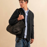 Die Shoulder Bag ORIGINAL XL von LABEL17, aus geschmeidigem Nappaleder von Hand geflochten, bietet grosszügigen Stauraum und eine variable Silhouette. Seitliche Druckknöpfe ermöglichen es, Form und Volumen der Tasche anzupassen. So wird aus dem geräumigen Weekender im Handumdrehen eine alltagstaugliche Begleiterin. Eine herausnehmbare, ebenfalls handgeflochtene Lederpouch sorgt für Ordnung im Inneren. Unisex.